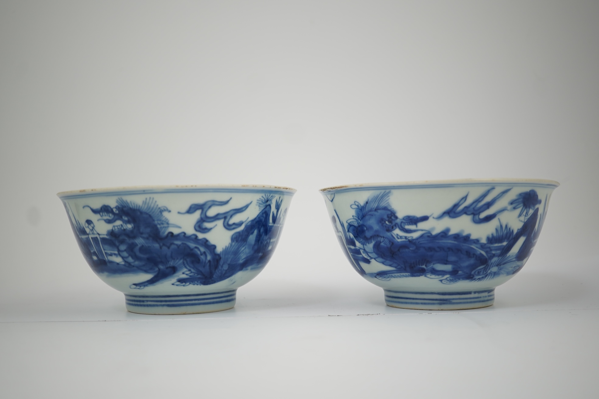 A pair of Chinese Transitional blue and white 'mythical beasts' bowls, early Kangxi period